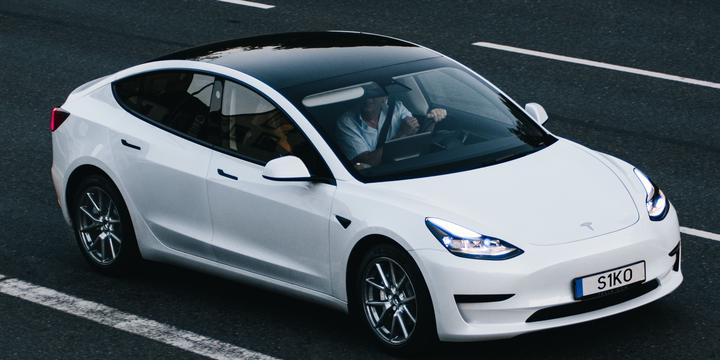 Photo of a white Tesla Model 3 on the road